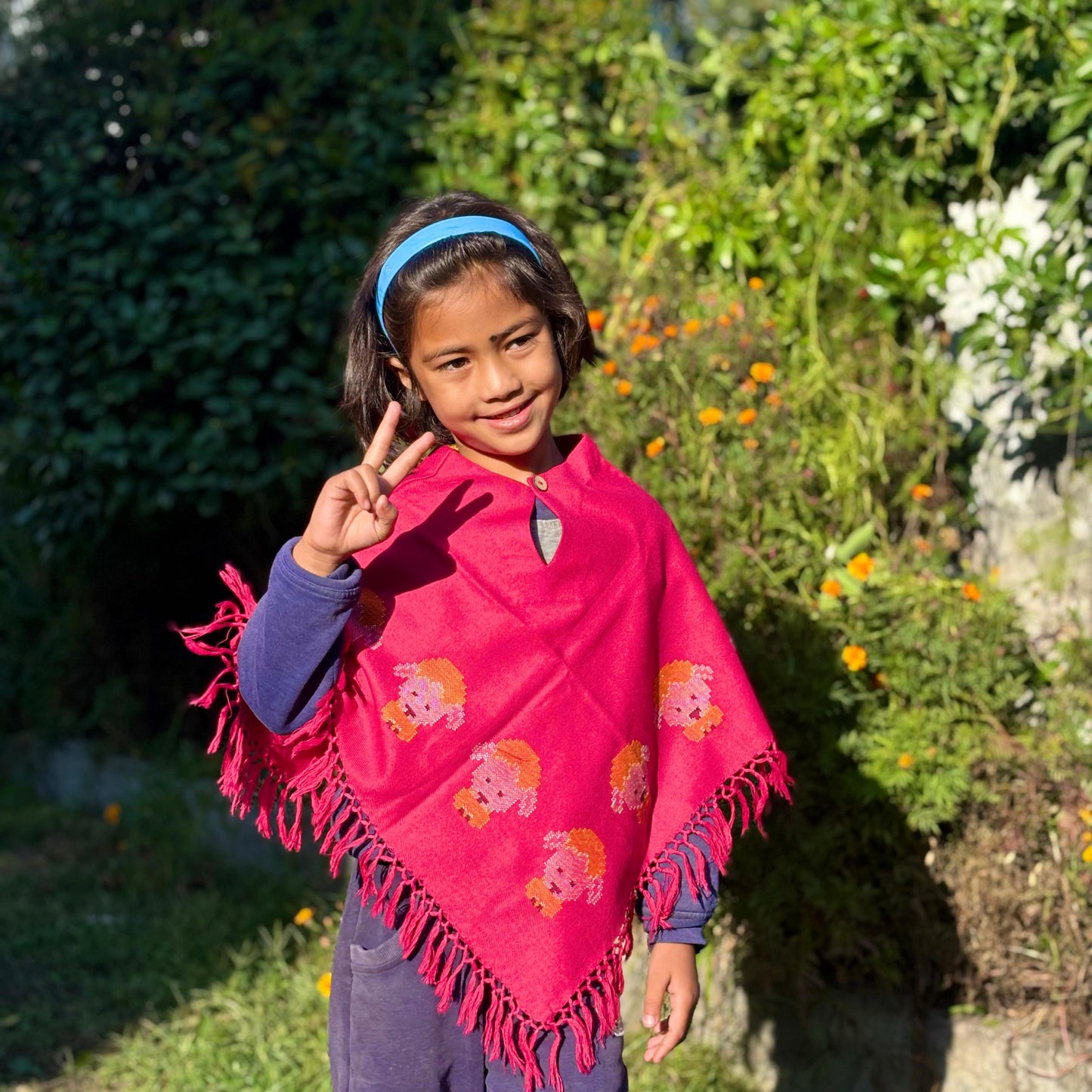 Young girl wearing a Handwoven Himachali merino wool kids poncho with tassel edges