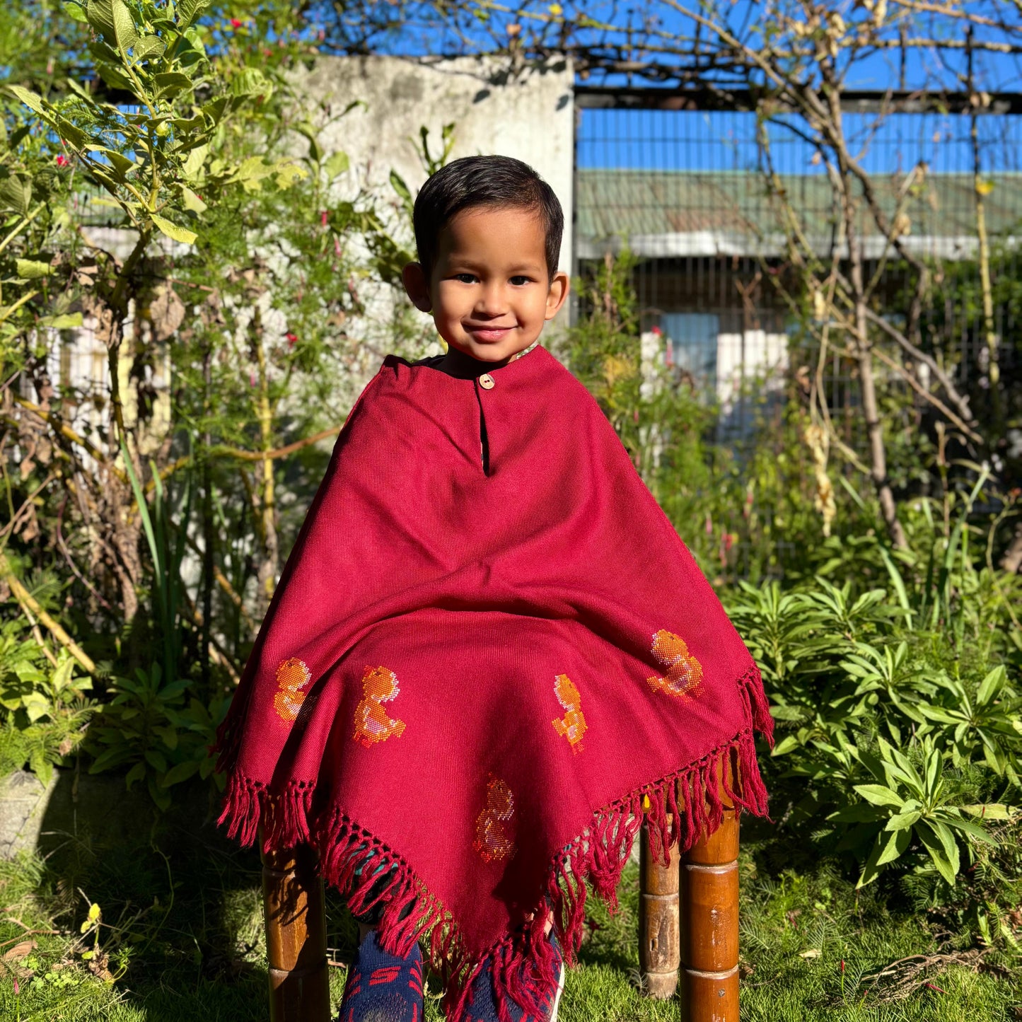 Handwoven kids poncho with duck motif and tassel edges in red color