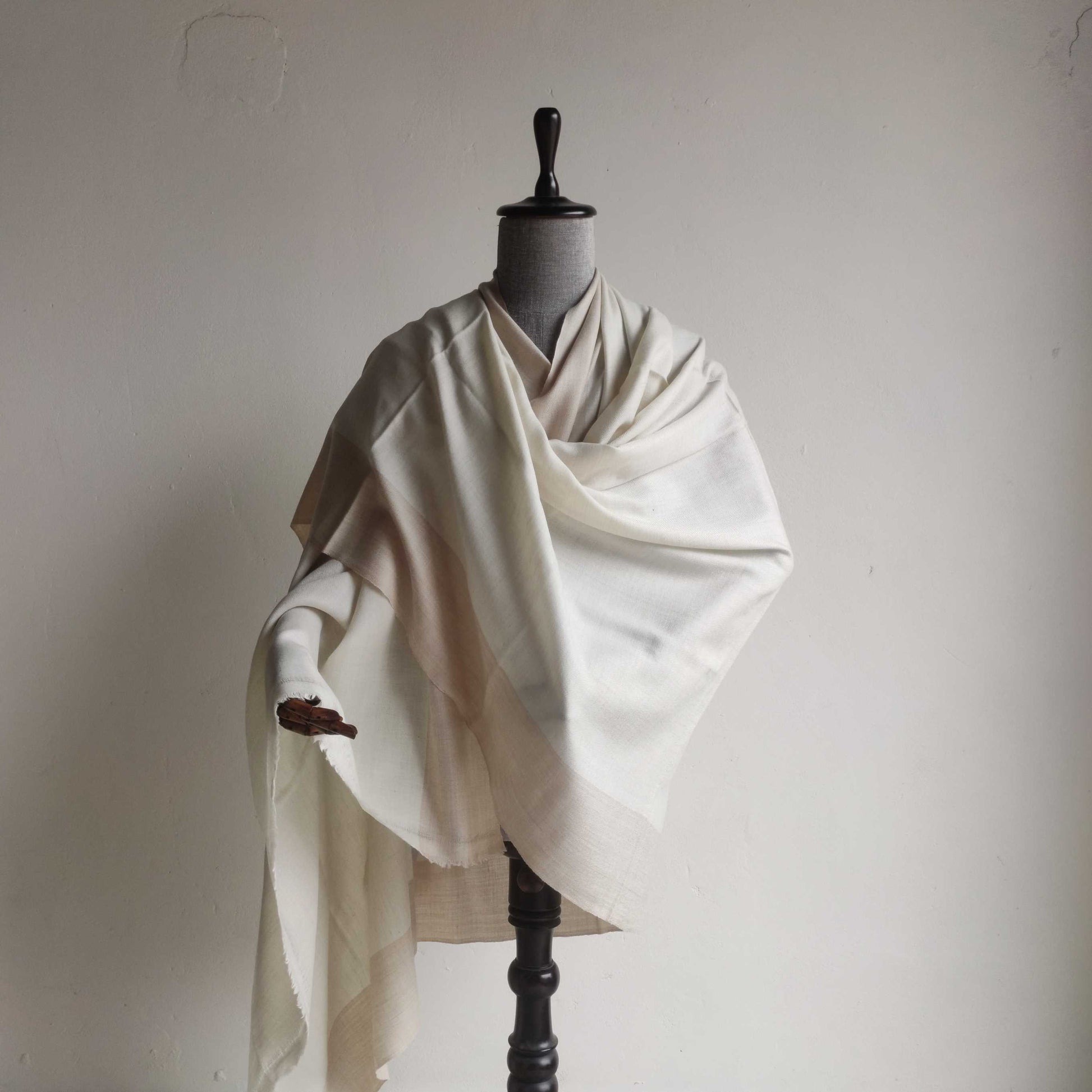 Mannequin wearing a white Men's shawl(loi) against a plain background
