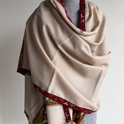 Beige Pure merino Kullu shawl with with red and green Kullu patti border draped over a mannequin against a white background