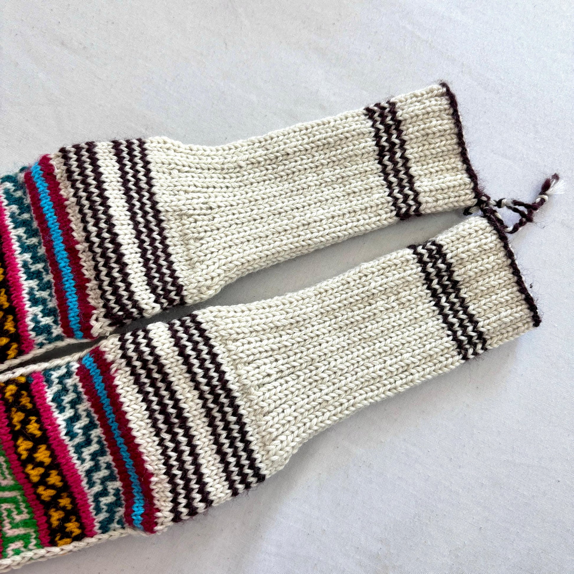 Pair of knitted socks with colorful patterns made from merino wool